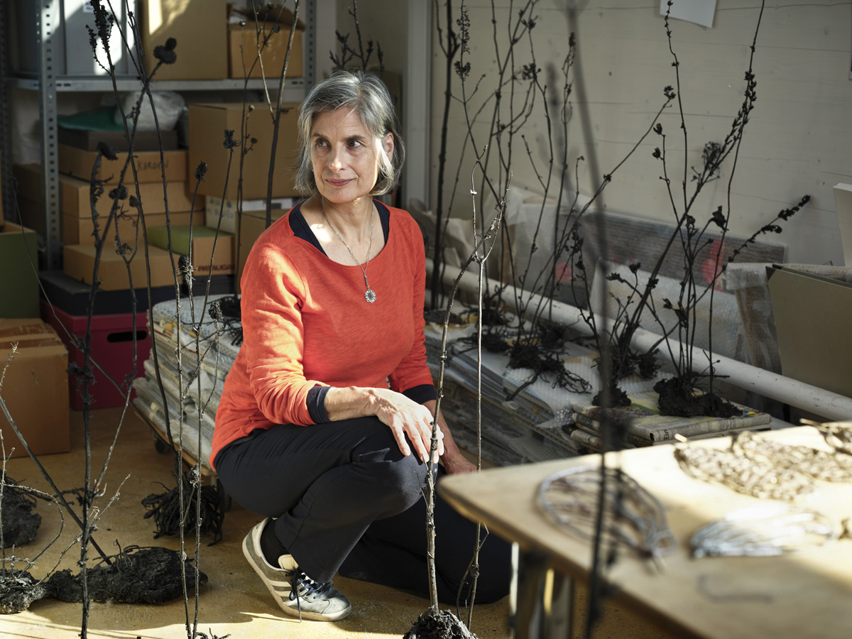 Die Künstlerin Ursula Palla in ihrem Atelier in Zürich Altstetten, um sie herum Bronze-Pflanzen aus der Videoinstallation "Empty Garden"